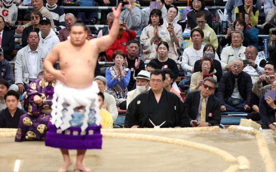 豊昇龍（手前）の横綱土俵入りを携帯で撮影する笑福亭鶴瓶（右端）＝撮影・中田匡峻