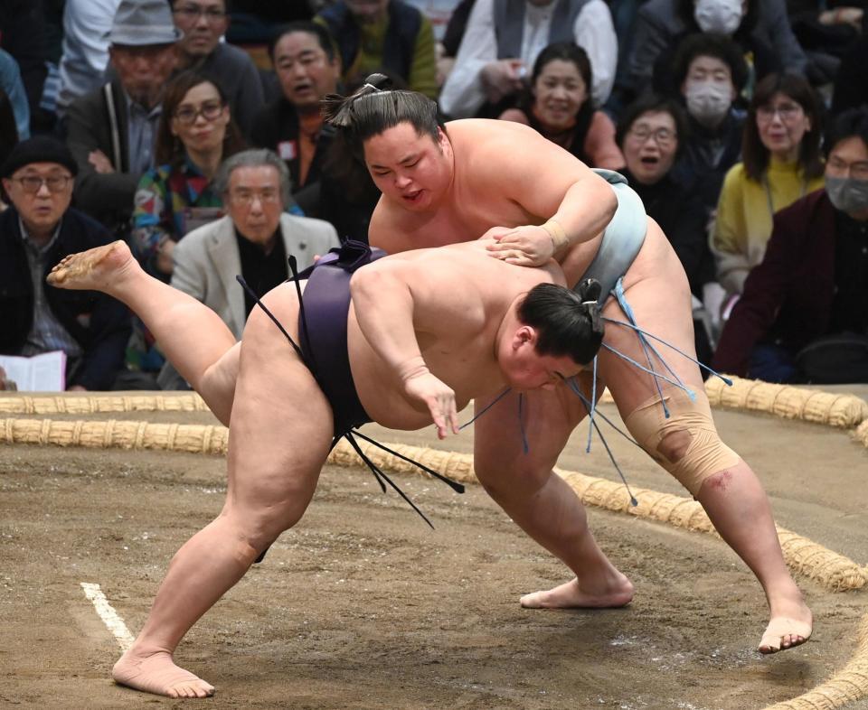 琴勝峰（右）がはたき込みで義ノ富士を破る