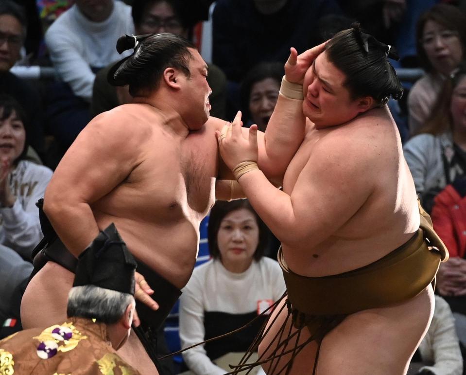 霧島（左）が厳しく攻め、寄り倒しで王鵬を破る