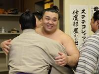 支度部屋に戻り、関係者と笑顔で抱き合う霧島