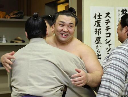 支度部屋に戻り、関係者と笑顔で抱き合う霧島　