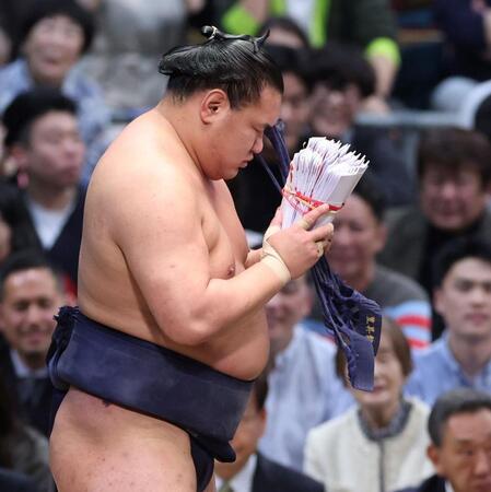 安青錦にを掛け投げで下し、懸賞金の束を手にする豊昇龍（撮影・中田匡峻）