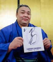 大相撲春場所で３度目の優勝を果たし、色紙を手にポーズをとる霧島