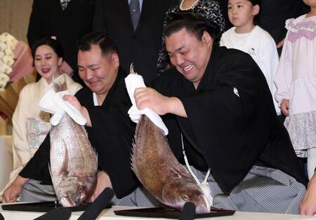 笑顔で鯛を持つ霧島。左は音羽山親方（撮影・中田匡峻）