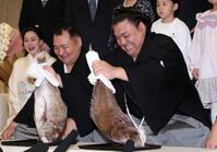 笑顔で鯛を持つ霧島。左は音羽山親方（撮影・中田匡峻）