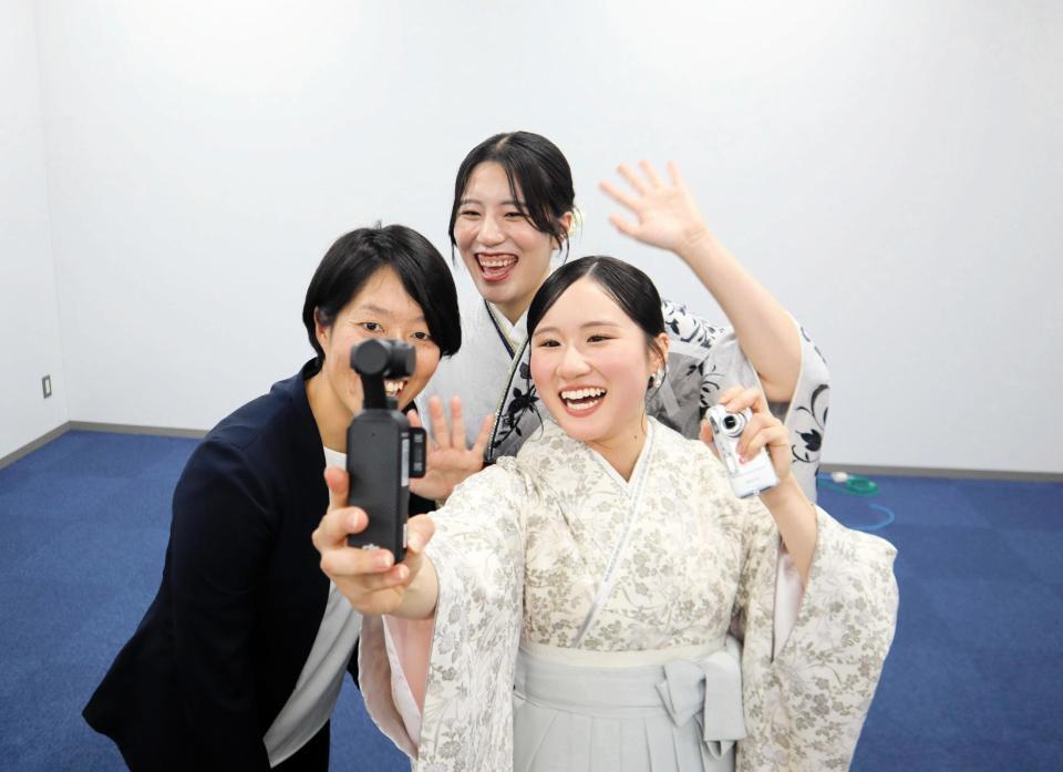 撮影機器を持って笑顔を見せる金戸（右）