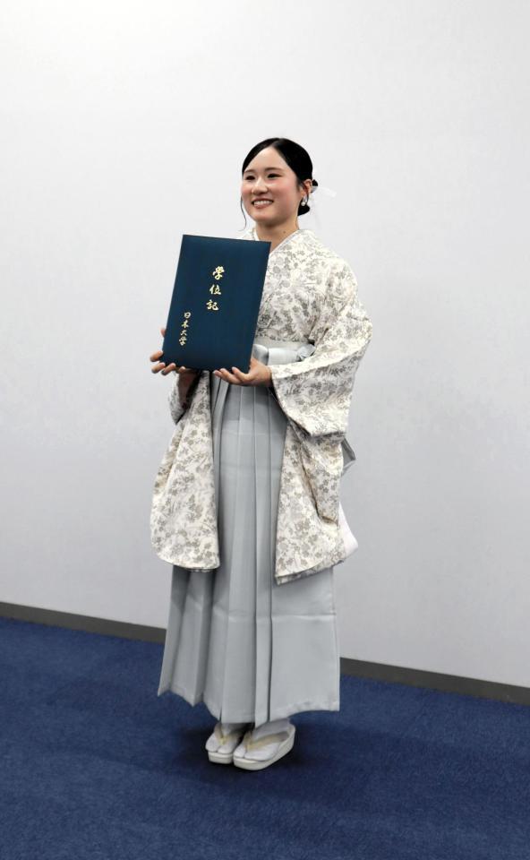 学位記を持って笑顔を見せる金戸