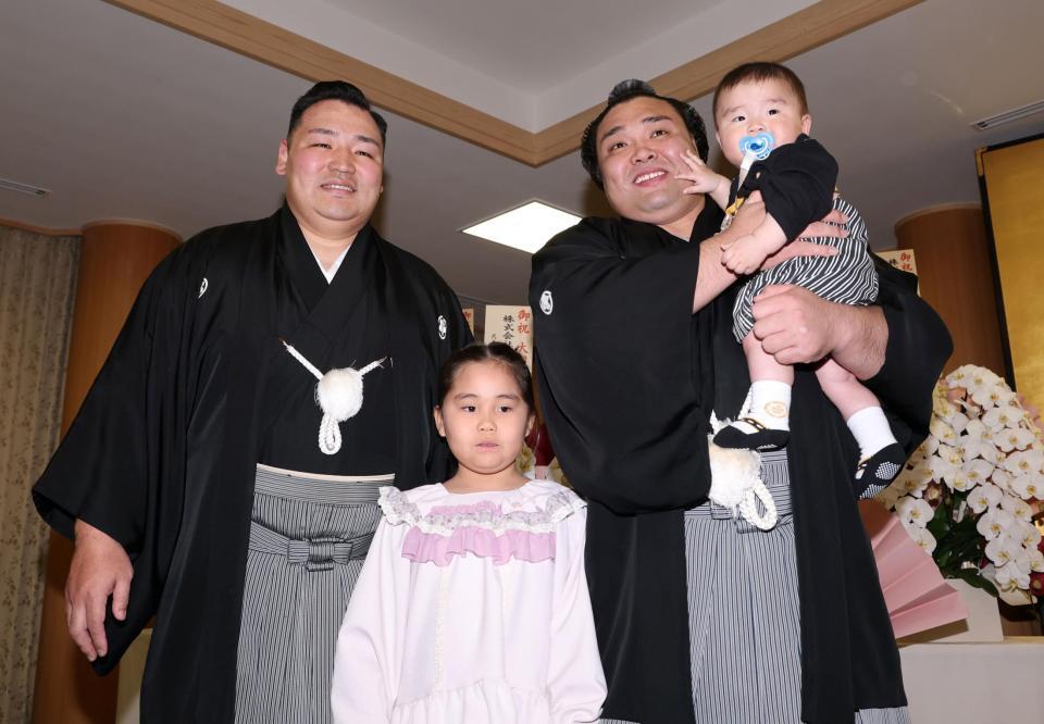 長男・トゥグドゥル君を抱っこし、笑顔の霧島。左は師匠の音羽山親方、中央は長女のアヤゴーちゃん（撮影・中田匡峻）