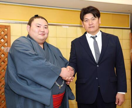 　立浪親方（右）と握手を交わす大花竜