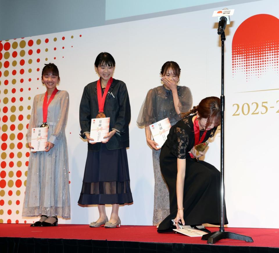 スピーチに向かう際、誤って目録を落としてしまう佐藤早也伽（右）＝撮影・伊藤笙子