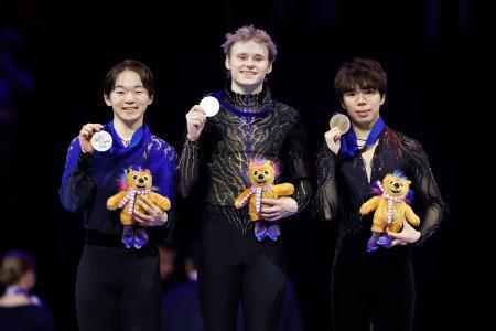 　男子の表彰式でメダルを掲げる（左から）２位の鍵山優真、優勝のイリア・マリニン、３位の佐藤駿＝プラハ（共同）