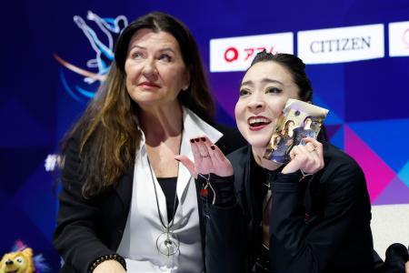 　アイスダンスフリーの演技を終え、キスアンドクライで亡き兄クリスさんの写真を掲げるアリソン・リード（右）＝プラハ（共同）