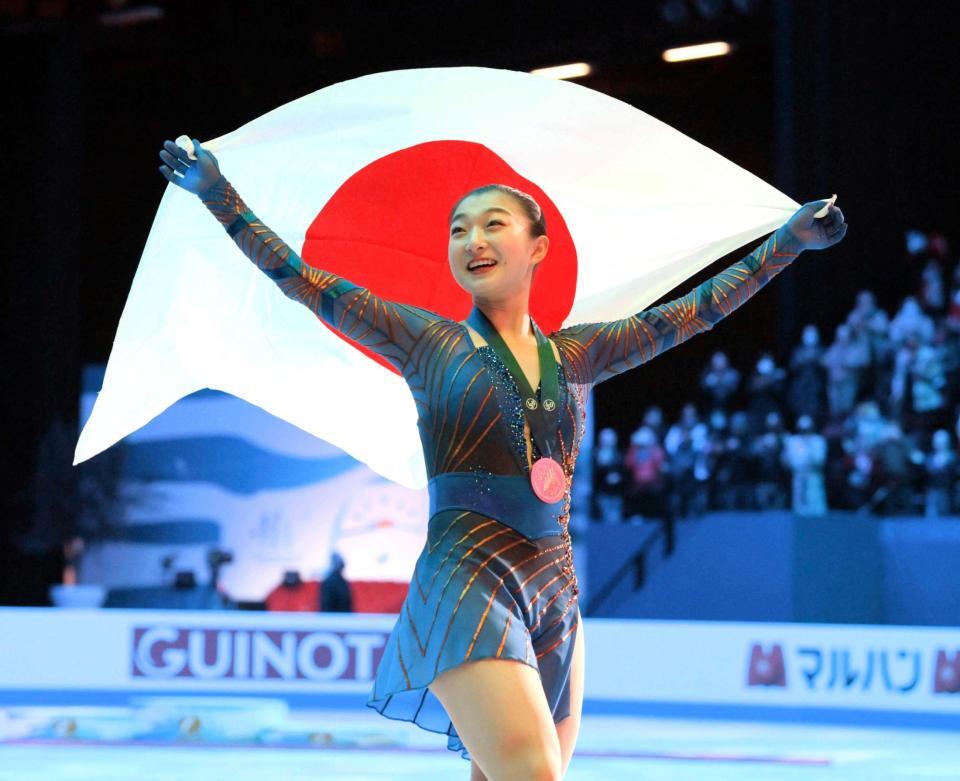 　フィギュアスケートの世界選手権女子で初優勝し、日の丸を掲げる坂本花織＝２５日、フランス・モンペリエ（共同）