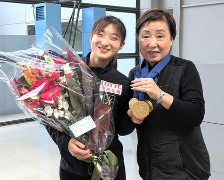 　中野園子コーチ（右）に世界選手権のメダルをかける坂本花織