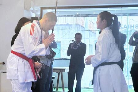 メダルを返還され、感謝を込めて一礼するホルナさん（左）