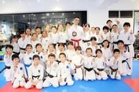 返還されたメダルを手に笑顔を見せるホルナさん（中央）と、皆思道場の道場生ら（全日本空手道連盟提供）