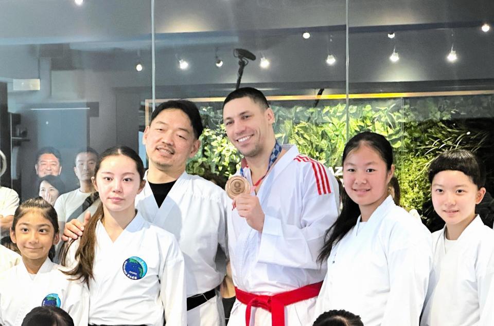 返還された銅メダルを手に笑顔を見せるホルナさん（右から３人目）