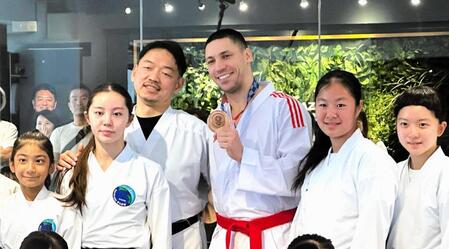 　返還された銅メダルを手に笑顔を見せるホルナさん（中央右）