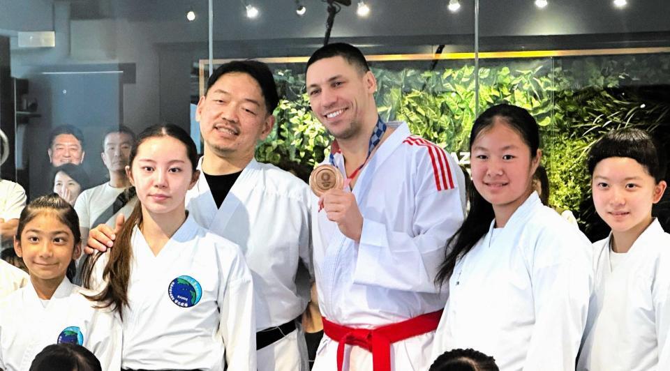 　返還された銅メダルを手に笑顔を見せるホルナさん（中央右）