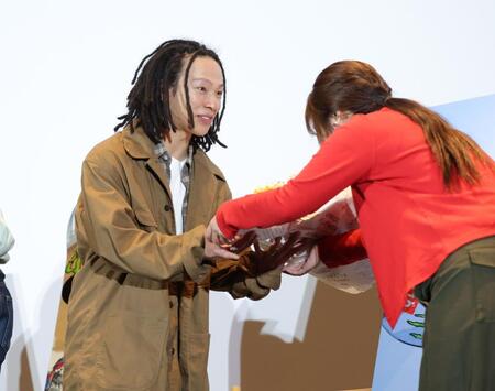 花束を笑顔で受け取る平野歩夢＝東京・丸の内ピカデリー（撮影・西岡正）