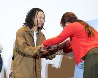 花束を笑顔で受け取る平野歩夢＝東京・丸の内ピカデリー（撮影・西岡正）