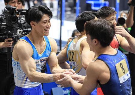 ６連覇を達成し、２位の岡慎之助（右）と握手する橋本大輝