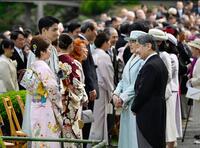 春の園遊会で、五輪フィギュアスケート・ペアで金メダルの三浦璃来（左手前）、木原龍一（同手前から２人目）と言葉を交わされる天皇、皇后両陛下