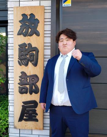 　放駒部屋の前でポーズをとる白神嶺治＝２０日、東京都足立区