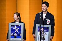 壇上で笑顔を見せる三浦璃来さん㊧、木原龍一さん㊨（アフロ／ＪＳＦ提供）