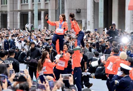 ミラノ・コルティナ冬季五輪・パラリンピックの応援感謝パレードでリフトをして写真撮影するフィギュアペア金メダルの三浦璃来、木原龍一