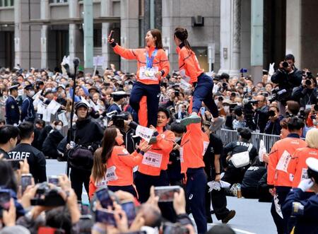 ミラノ・コルティナ冬季五輪・パラリンピックの応援感謝パレードでリフトをして写真撮影するフィギュアペア金メダルの三浦璃来、木原龍一ら