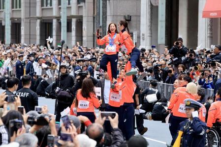 ミラノ・コルティナ冬季五輪・パラリンピックの応援感謝パレードでリフトをして写真撮影するフィギュアペア金メダルの三浦璃来、木原龍一