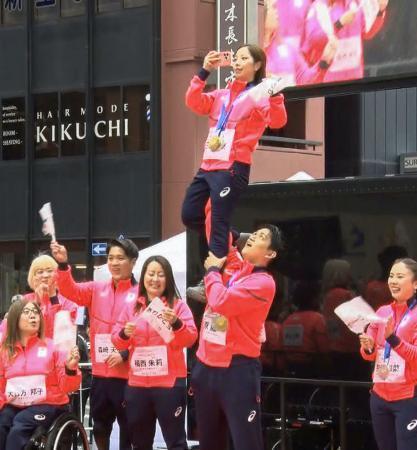 　ミラノ・コルティナ五輪・パラリンピックの日本選手団による「応援感謝パレード」で、リフトを披露するフィギュアスケート・ペアの三浦璃来（上）、木原龍一組＝２５日午前、東京・日本橋