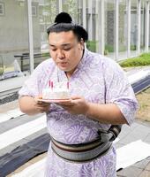 誕生日ケーキのろうそくの火を消す霧島