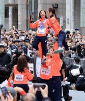 ミラノ・コルティナ冬季五輪・パラリンピックの応援感謝パレードでリフトをして写真撮影するフィギュアペア金メダルの三浦璃来、木原龍一