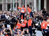 ミラノ・コルティナ冬季五輪・パラリンピックの応援感謝パレードでリフトをして写真撮影するフィギュアペア金メダルの三浦璃来、木原龍一ら