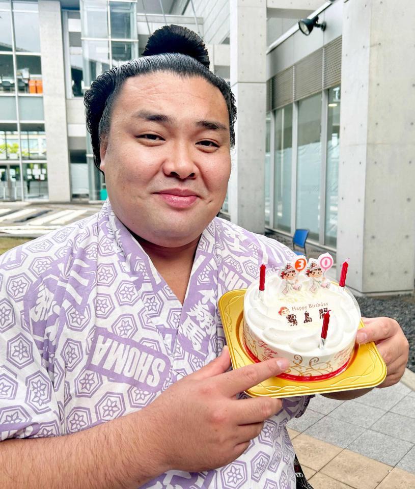 　３０歳の誕生日を迎え、報道陣から贈られたケーキを手に笑顔の霧島