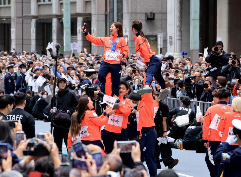 ミラノ・コルティナ冬季五輪・パラリンピックの応援感謝パレードでリフトをして写真撮影するフィギュアペア金メダルの三浦璃来、木原龍一ら