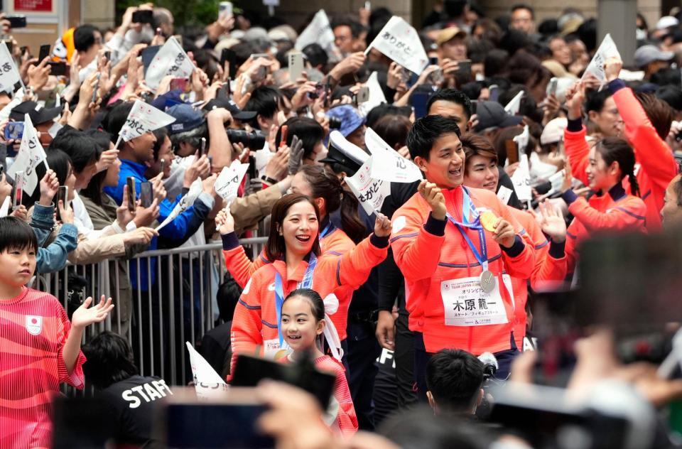 ミラノ・コルティナ五輪・パラリンピックの日本選手団による「応援感謝パレード」で、東京・日本橋を練り歩くフィギュアスケート・ペアの三浦璃来（左）、木原龍一組＝25日午前