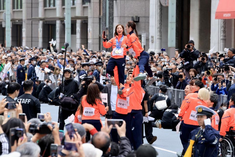 ミラノ・コルティナ冬季五輪・パラリンピックの応援感謝パレードでリフトをして写真撮影するフィギュアペア金メダルの三浦璃来、木原龍一