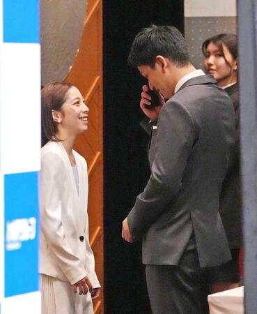　会見前に舞台袖で涙を拭う木原龍一さん（右）を笑顔で見つめる三浦璃来さん