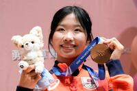 ミラノ・コルティナ冬季五輪で銅メダルを獲得し、勇志国際高が開いた祝賀会で写真撮影に応じるフィギュアスケート女子の中井亜美