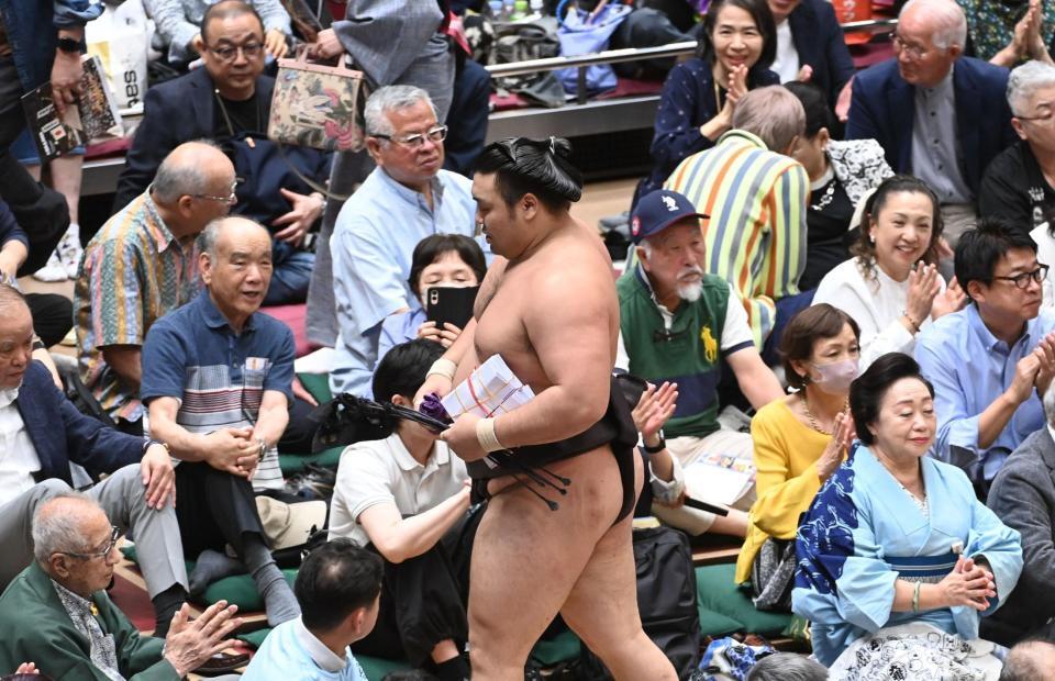 分厚い懸賞金の束を小脇に抱え花道を引きあげる霧島（撮影・園田高夫）