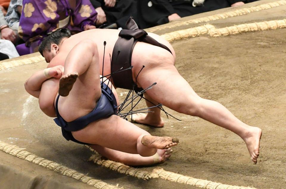 平戸海（下）をすくい投げで下し、全勝を守った霧島（撮影・佐藤厚）