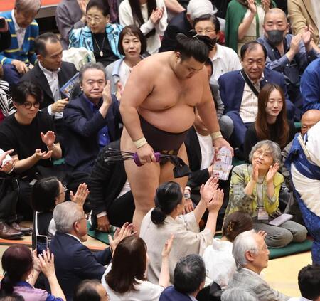分厚い懸賞金の束を手に引き上げる霧島