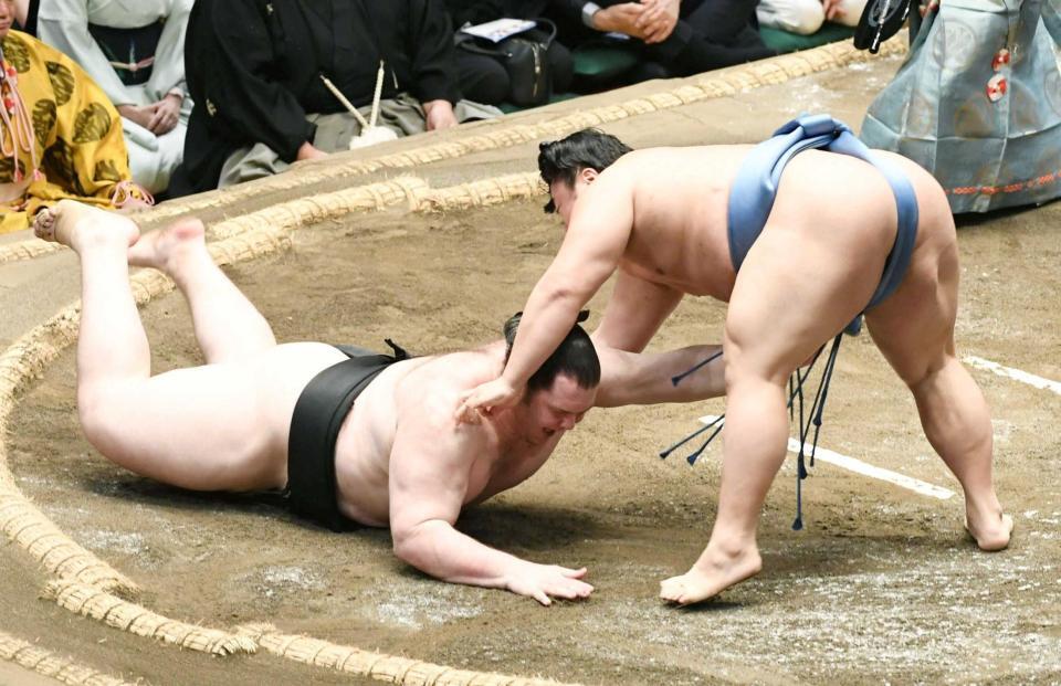 　上手出し投げで獅司（左）を破る翔猿（撮影・佐藤厚）