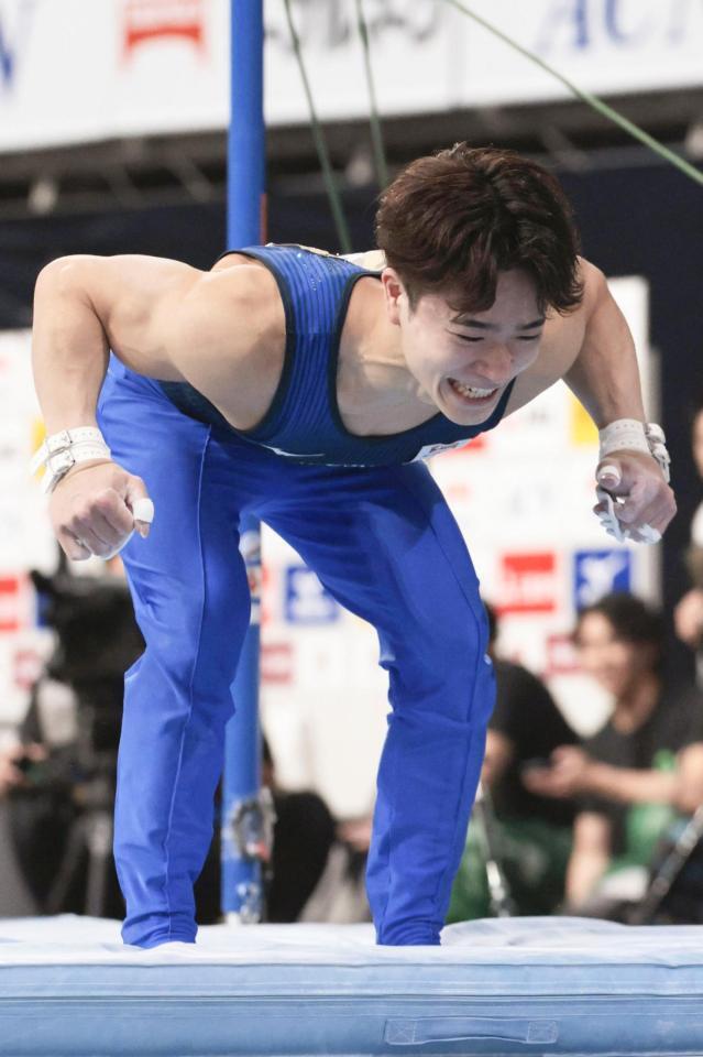 男子個人総合　鉄棒で着地を決め、笑顔の岡慎之助