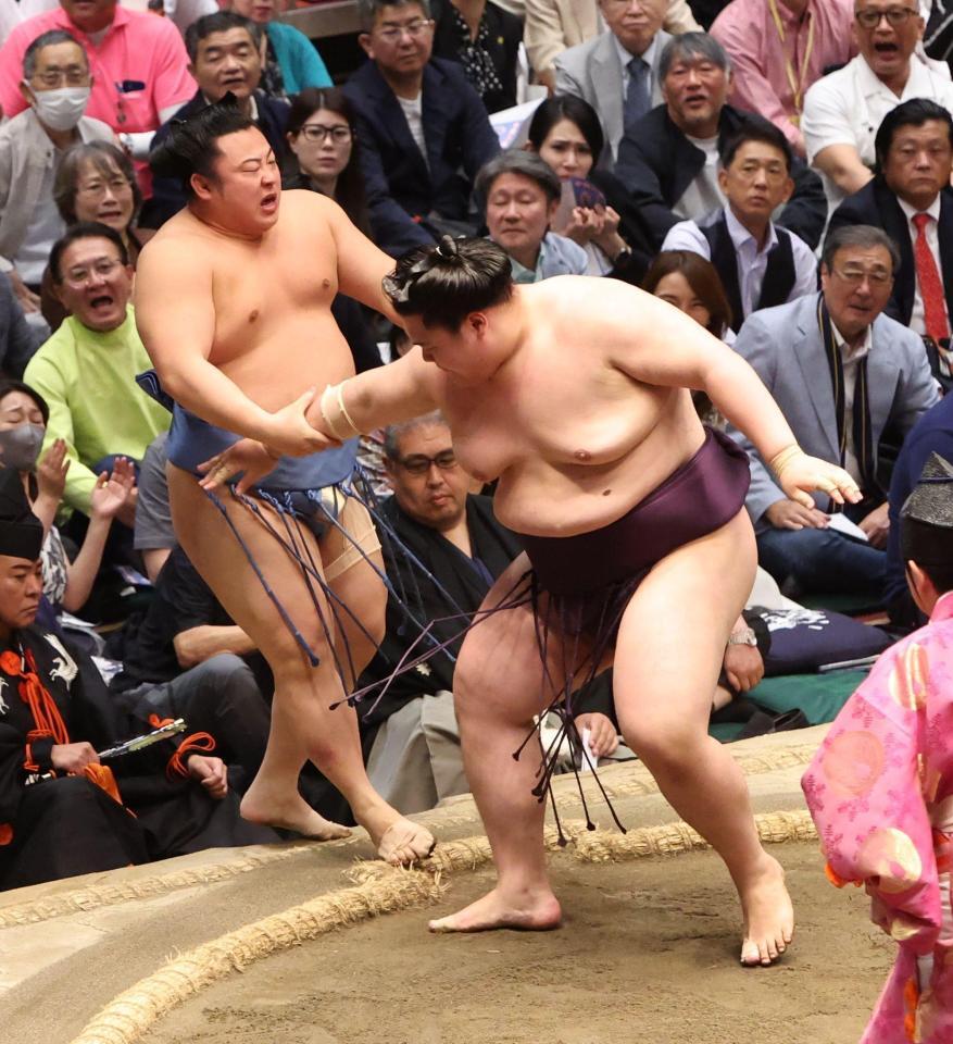 翔猿（左）を押し出しで破り勝ち越しを決めた王鵬
