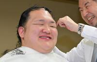 断髪式を終え、調髪に臨む元北勝富士の大山親方（左）