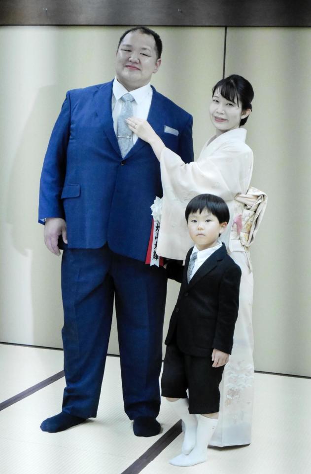 整髪を終え真美夫人からネクタイを直される大山親方と春仁くん＝両国国技館